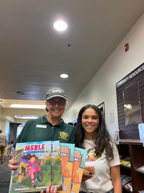 Man in green shirt and cap and woman in white shirt holding vintage action figure boxes indoors