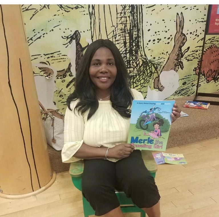 Woman sitting in green chair holding Merle book with illustrated forest backdrop and storybooks on table